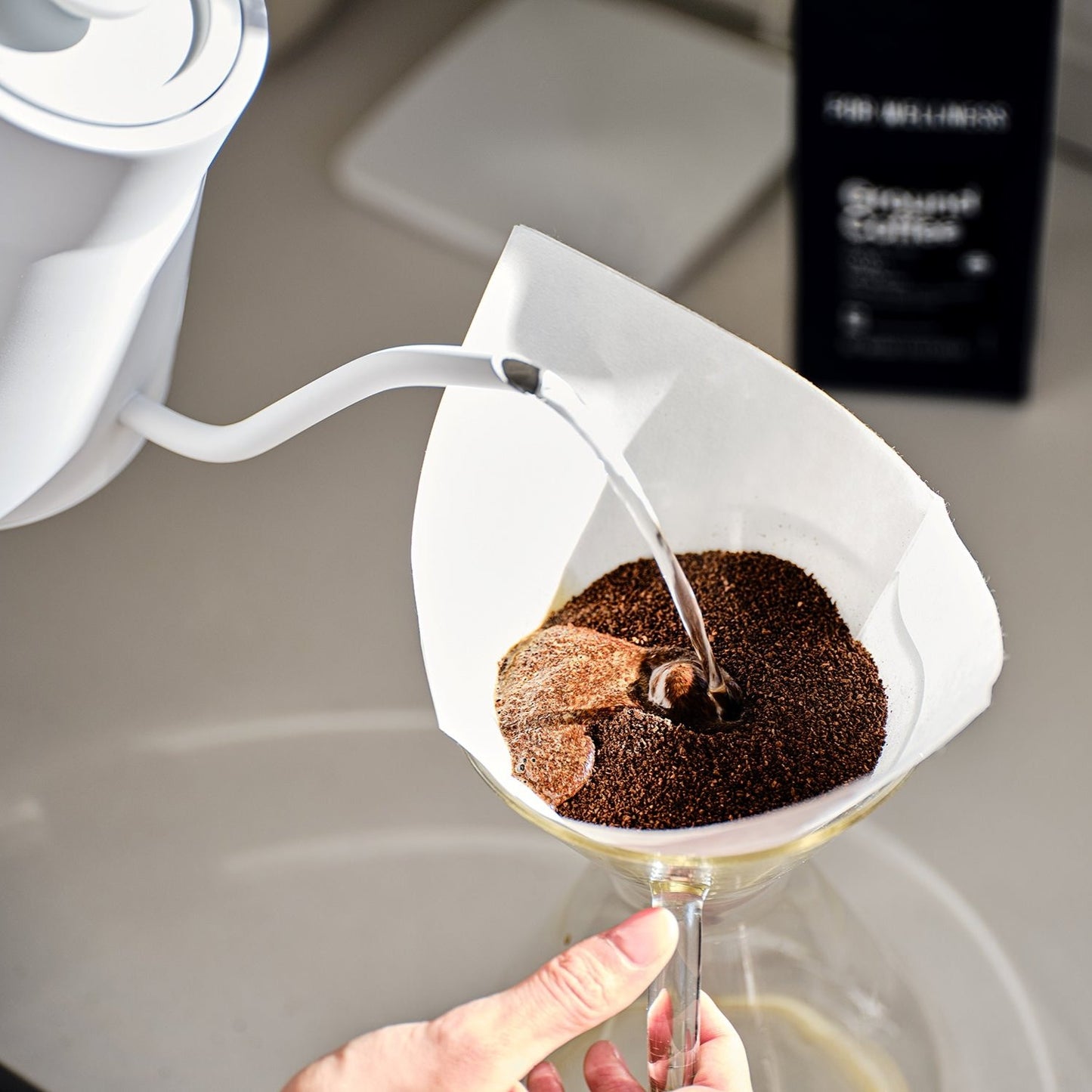 Pouring water over coffee grounds in a filter.