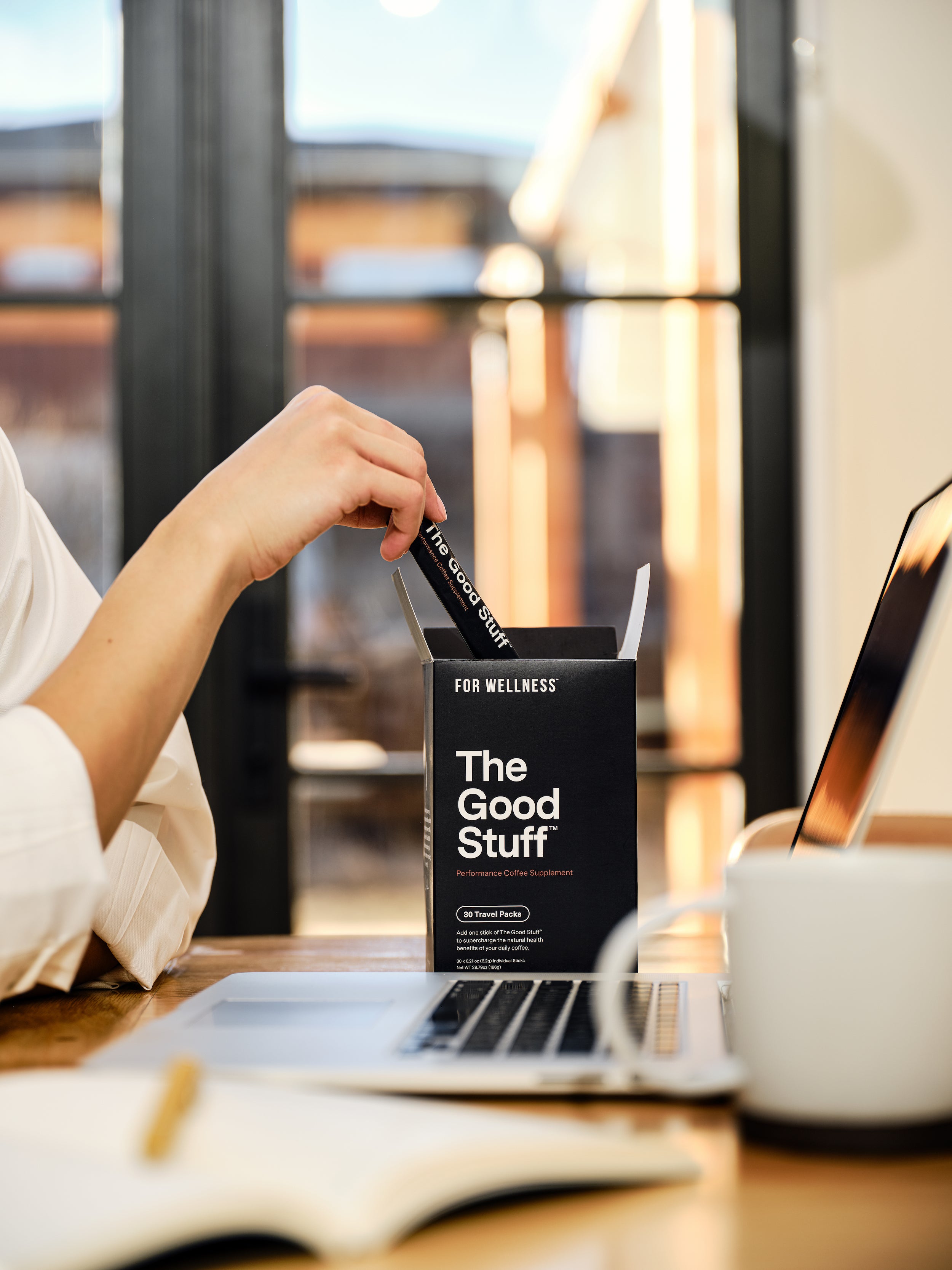 Woman reaching for The Good Stuff Focus travel sticks on desk